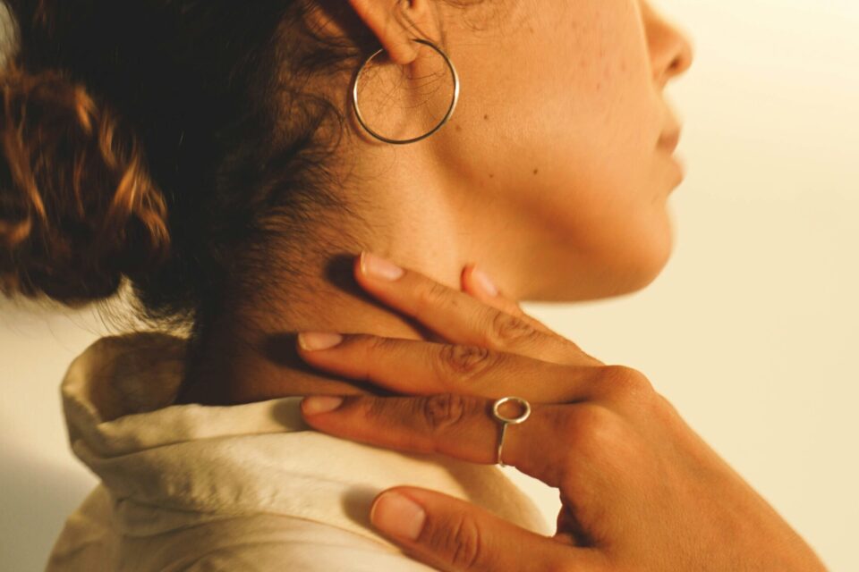 Woman holding the back of her neck as if it's painful