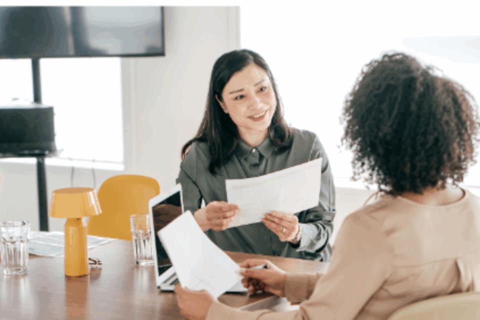 Two women speaking sat at a table